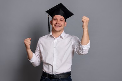 Photo of Happy student after graduation on grey background