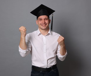 Photo of Happy student after graduation on grey background