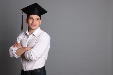 Photo of Happy student with crossed arms after graduation on grey background. Space for text