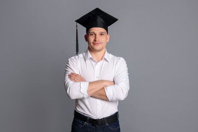 Photo of Student with crossed arms after graduation on grey background