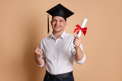 Photo of Happy student with diploma after graduation on beige background