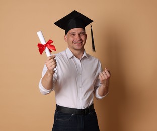 Photo of Happy student with diploma after graduation on beige background