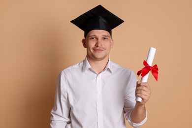 Photo of Student with diploma after graduation on beige background