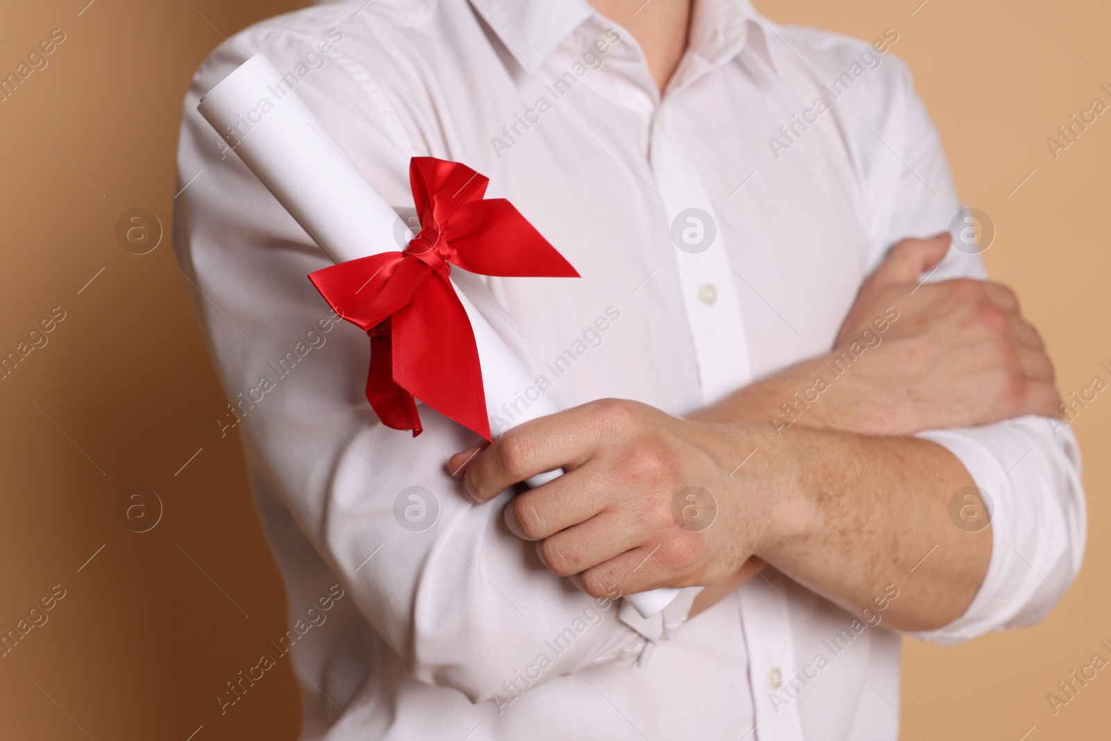 Student with diploma after graduation on beige background, closeup Photo of Student with diploma after graduation on beige background, closeup