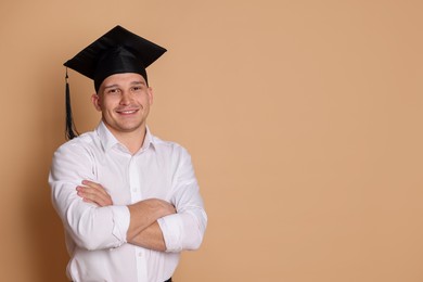 Photo of Happy student with crossed arms after graduation on beige background. Space for text