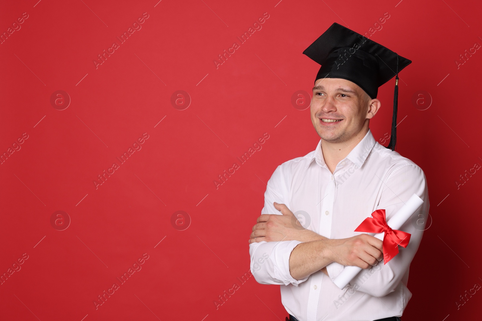 Happy student with diploma after graduation on red background. Space for text Photo of Happy student with diploma after graduation on red background. Space for text