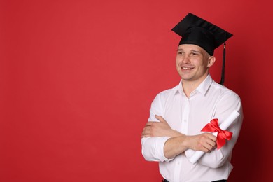 Photo of Happy student with diploma after graduation on red background. Space for text