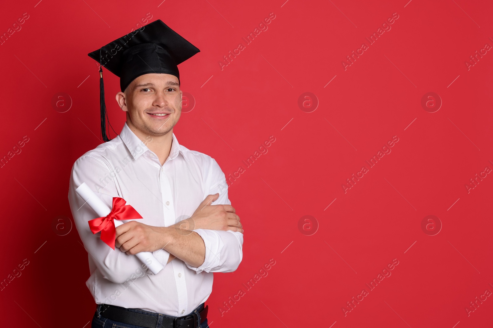 Happy student with diploma after graduation on red background. Space for text Photo of Happy student with diploma after graduation on red background. Space for text