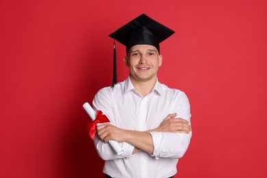 Photo of Happy student with diploma after graduation on red background