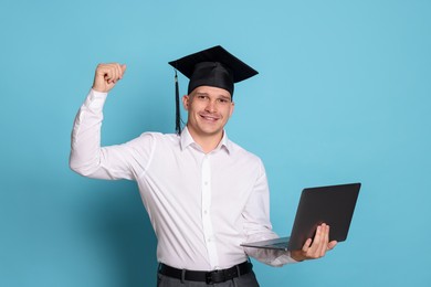Photo of Happy student with laptop after graduation on light blue background