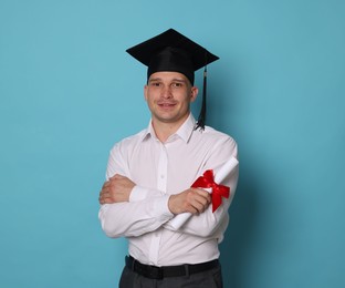 Photo of Happy student with diploma after graduation on light blue background