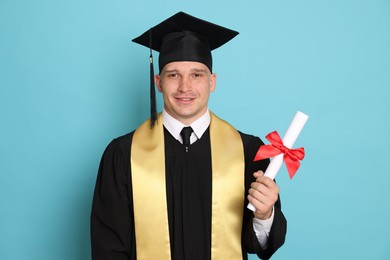 Photo of Happy student with diploma after graduation on light blue background