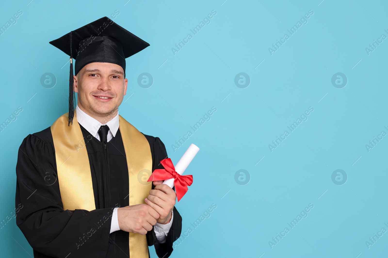 Happy student with diploma after graduation on light blue background. Space for text Photo of Happy student with diploma after graduation on light blue background. Space for text