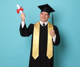 Photo of Happy student with diploma after graduation on light blue background