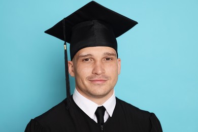 Photo of Portrait of student after graduation on light blue background