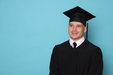 Photo of Happy student after graduation on light blue background. Space for text