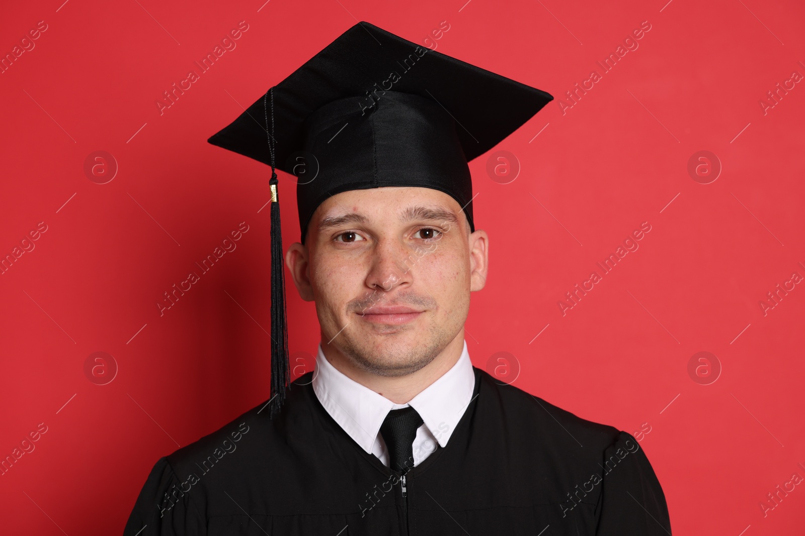 Portrait of student after graduation on red background Photo of Portrait of student after graduation on red background