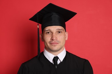 Photo of Portrait of student after graduation on red background