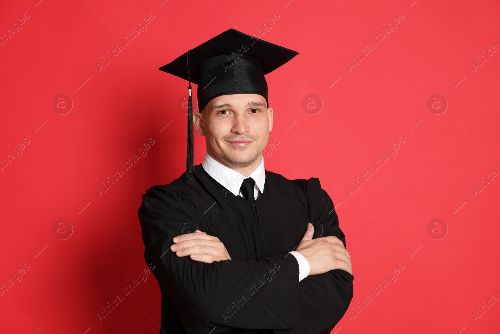 Portrait of student after graduation on red background Photo of Portrait of student after graduation on red background