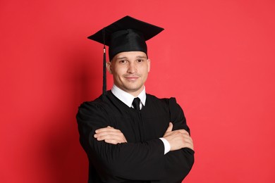 Photo of Portrait of student after graduation on red background