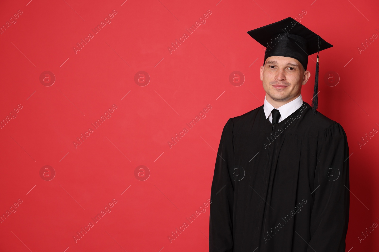 Student after graduation on red background. Space for text Photo of Student after graduation on red background. Space for text
