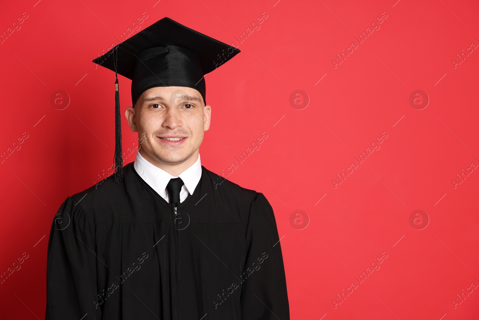 Happy student after graduation on red background. Space for text Photo of Happy student after graduation on red background. Space for text
