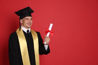 Photo of Happy student with diploma after graduation on red background. Space for text