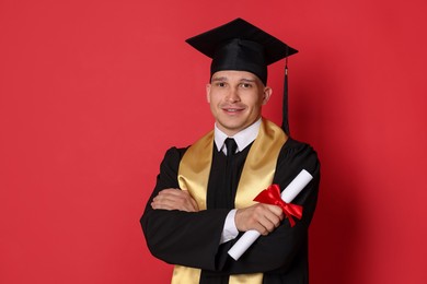 Photo of Happy student with diploma after graduation on red background
