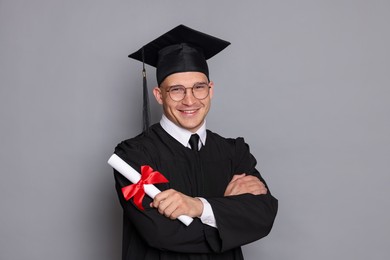 Photo of Happy student with diploma after graduation on grey background