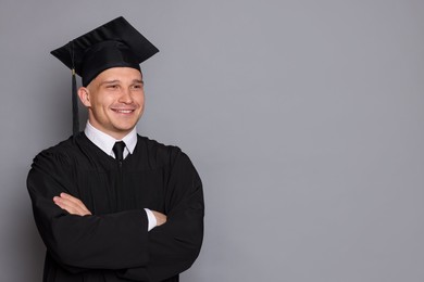 Photo of Happy student after graduation on grey background. Space for text