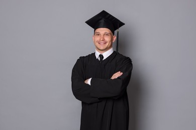 Photo of Happy student after graduation on grey background