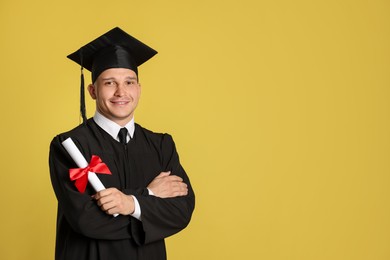 Photo of Happy student with diploma after graduation on yellow background. Space for text