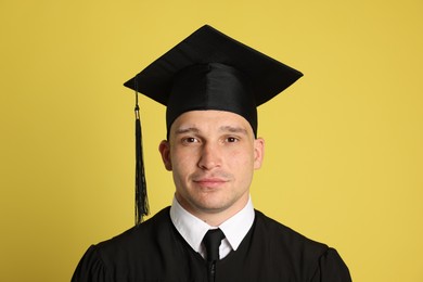 Photo of Portrait of student after graduation on yellow background