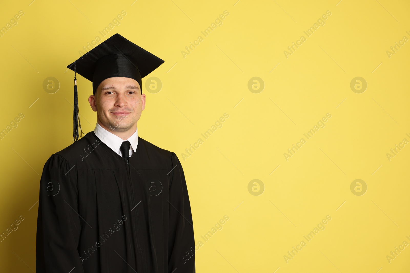 Student after graduation on yellow background. Space for text Photo of Student after graduation on yellow background. Space for text