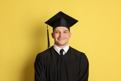 Photo of Portrait of student after graduation on yellow background