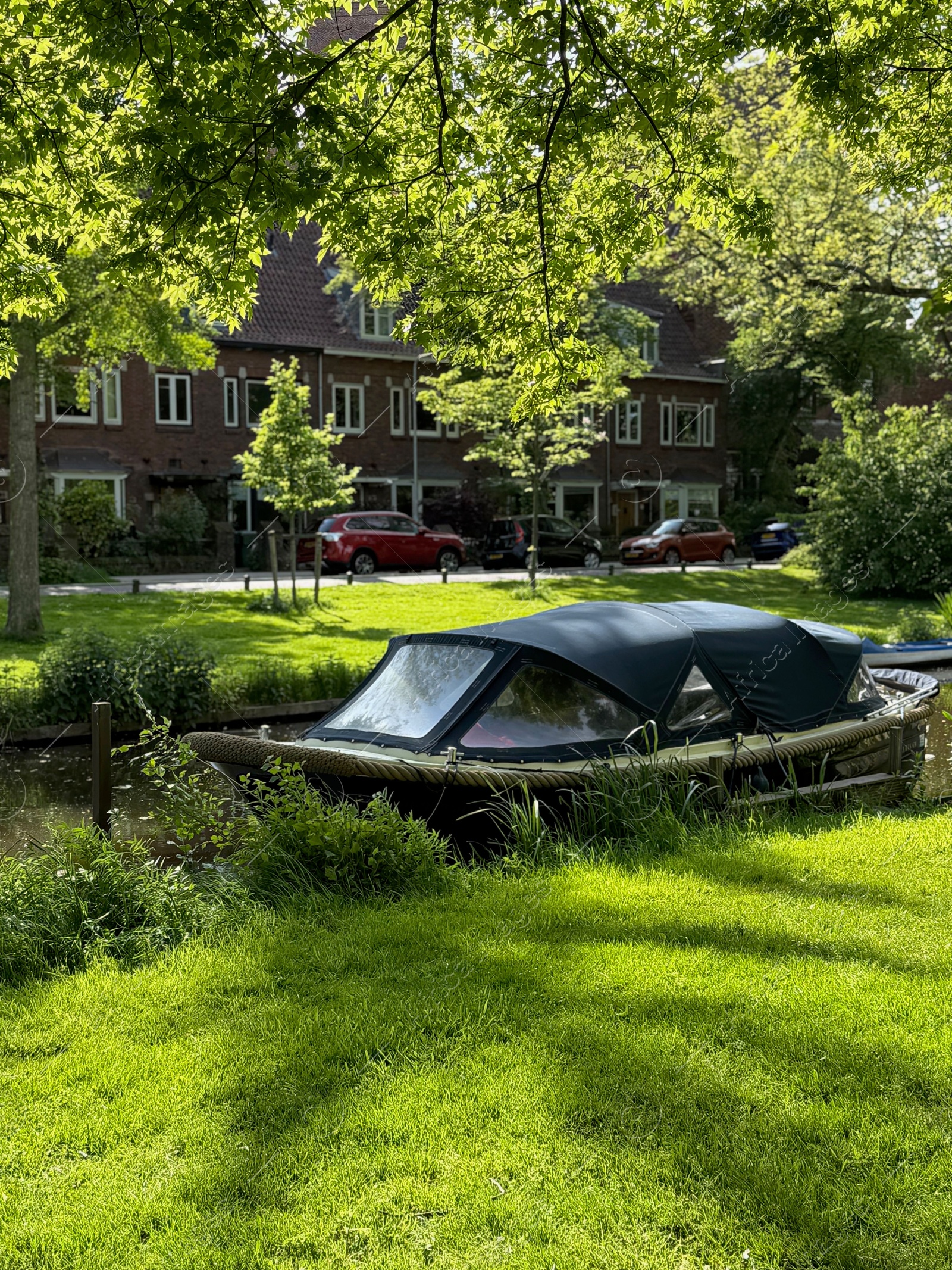 Beautiful canal with moored boat alongside road Photo of Beautiful canal with moored boat alongside road