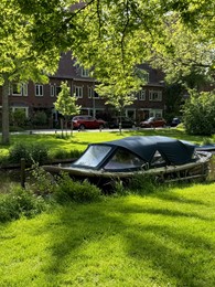 Photo of Beautiful canal with moored boat alongside road