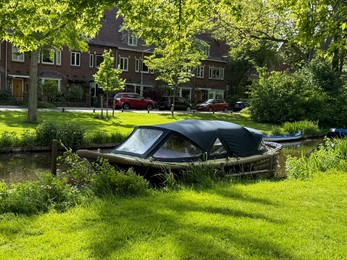 Photo of Beautiful canal with moored boat alongside road