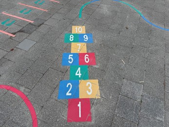 Photo of Hopscotch game drawn on asphalt outdoors, above view