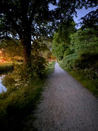 Photo of Picturesque view of canal, pathway and trees in park