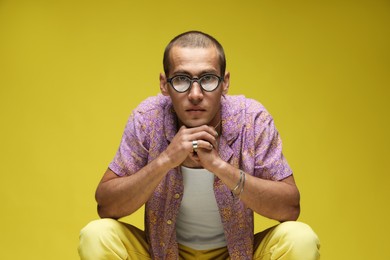 Photo of Fashionable portrait of handsome man in stylish outfit on color background