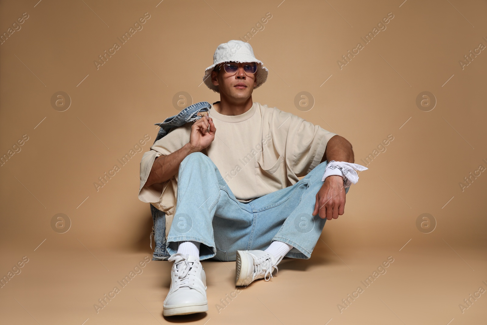 Fashionable portrait of handsome man in stylish outfit on brown background Photo of Fashionable portrait of handsome man in stylish outfit on brown background