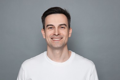 Photo of Smiling man after shaving on grey background
