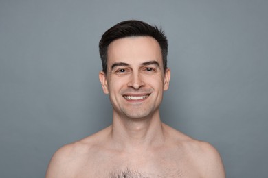 Photo of Smiling man after shaving on grey background