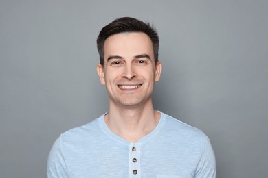 Photo of Smiling man after shaving on grey background