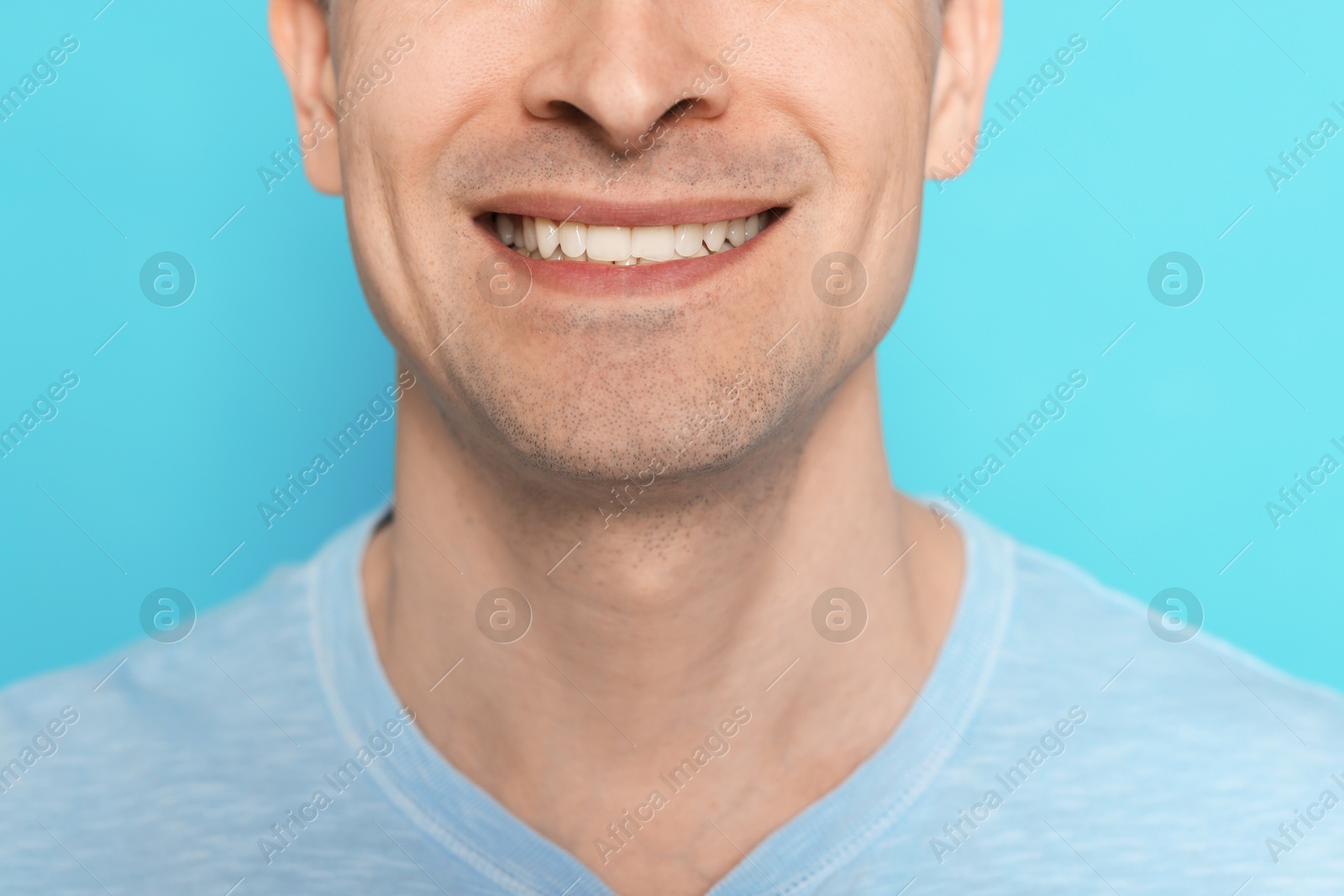Smiling man after shaving on light blue background, closeup Photo of Smiling man after shaving on light blue background, closeup