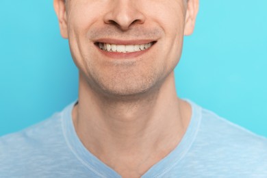 Photo of Smiling man after shaving on light blue background, closeup