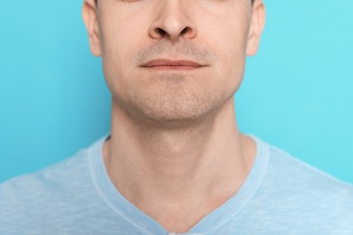 Photo of Man after shaving on light blue background, closeup