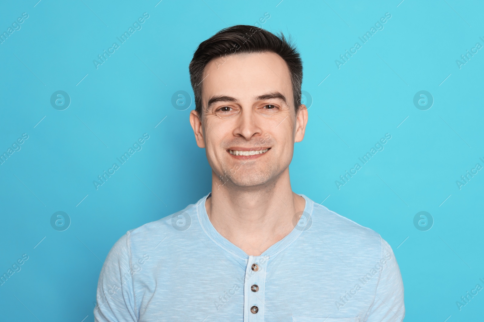 Smiling man after shaving on light blue background Photo of Smiling man after shaving on light blue background