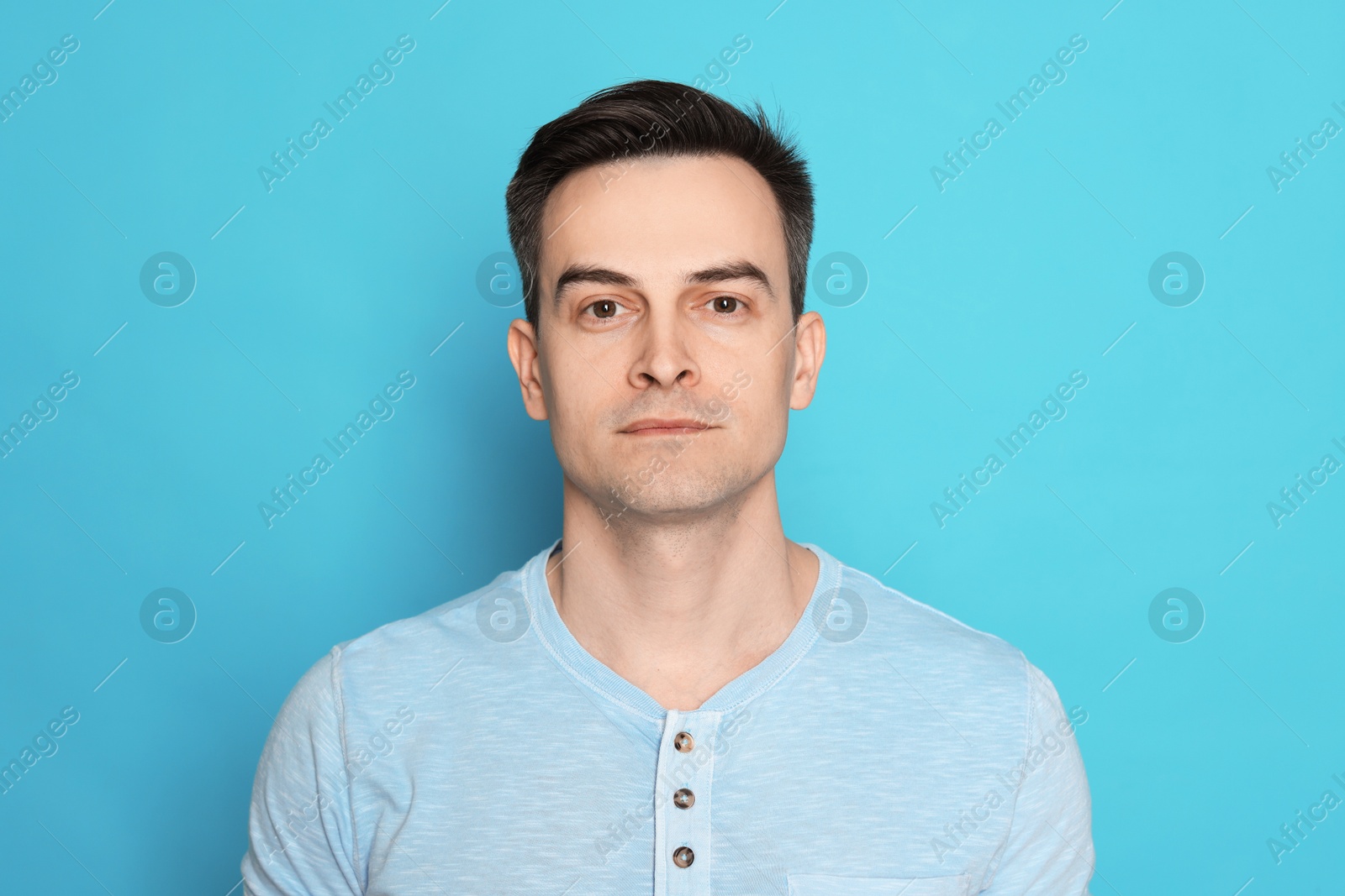 Handsome man after shaving on light blue background Photo of Handsome man after shaving on light blue background